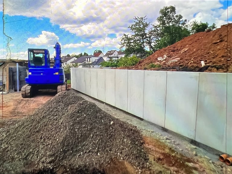 Blue excavator on construction site with white barrier fence and piles of soil and gravel